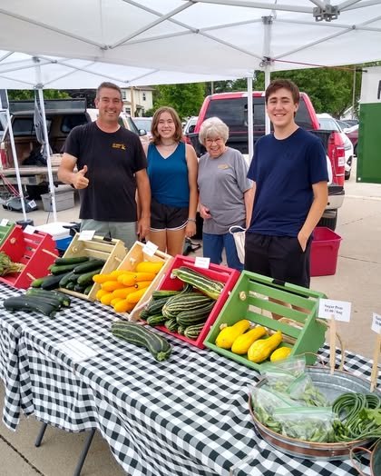 People Smiling at Market Booth
