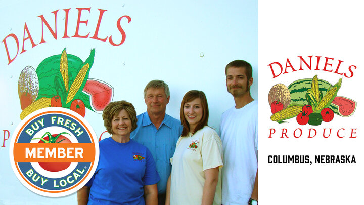 Daniels Produce Spotlight Photo showing a picture of the family in front of their produce trailer with farm logo on the trailer