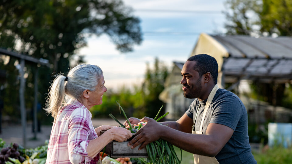 Farmer handing crops to a customer